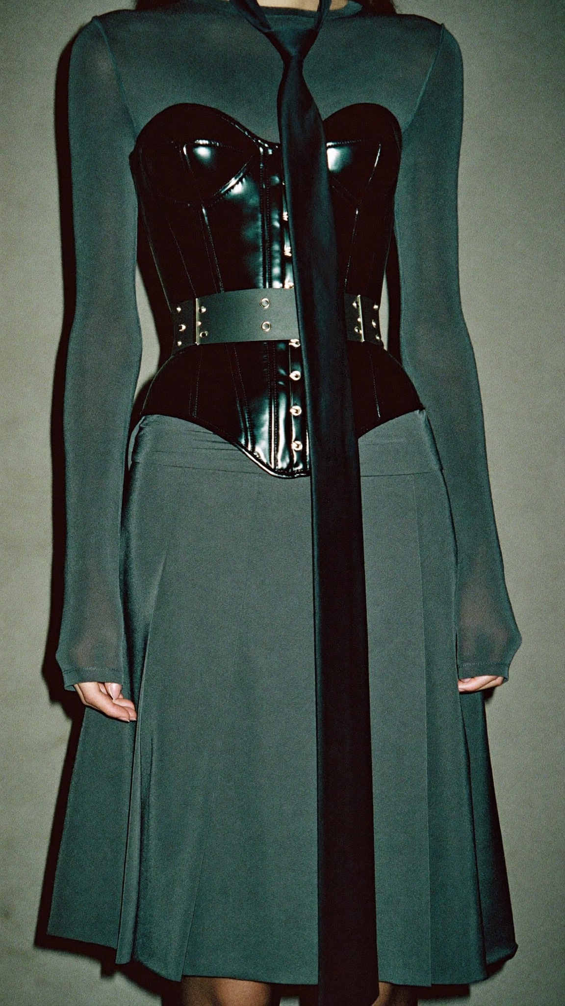 Black latex corset over sheer gray mesh with long tie and pleated skirt
